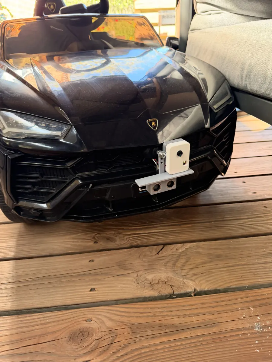 The camera and ultrasonic sensor on a printed bracket at the front bumper